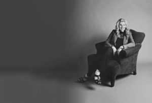 Black and white image of Cathy Sturm sitting in her armchair